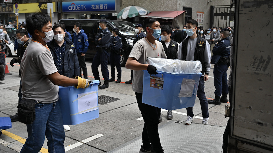 Polizeibeamte tragen beschlagnahmtes Material aus dem Büro von Stand News