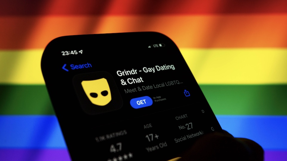 Grindr app in front of a rainbow flag