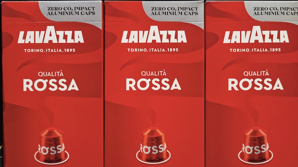 Drei Packungen mit Lavazza-Kapseln in einem Supermarktregal