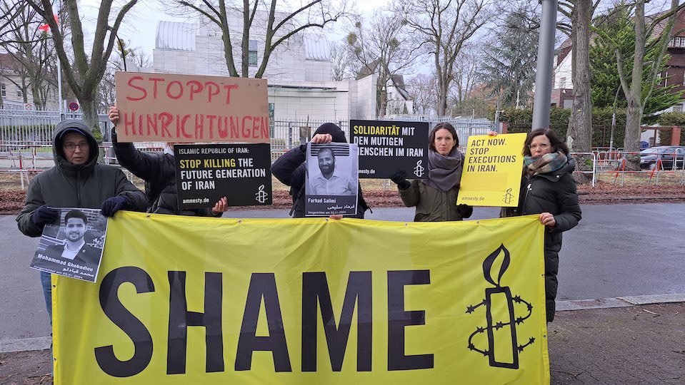 Mitglieder von Amnesty International halten Fotos der Hingerichteten vor der iranischen Botschaft in Berlin